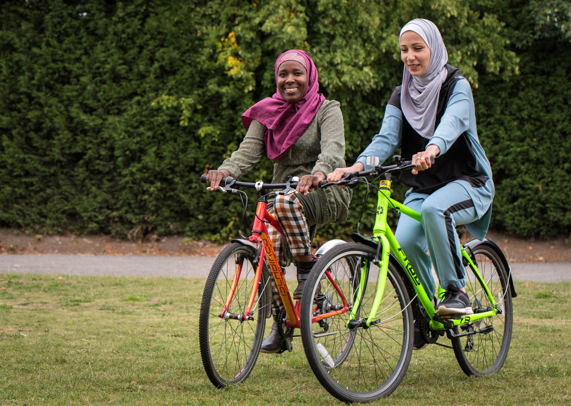 Two ladies cycling on grass